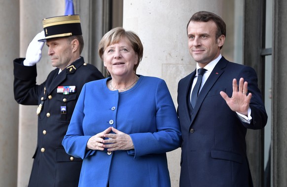 epa08057592 French President Emmanuel Macron (R) greets German Chancellor Angela Merkel as she arrives to attend a summit on Ukraine at the Elysee Palace in Paris, France, 09 December 2019. German Cha ...