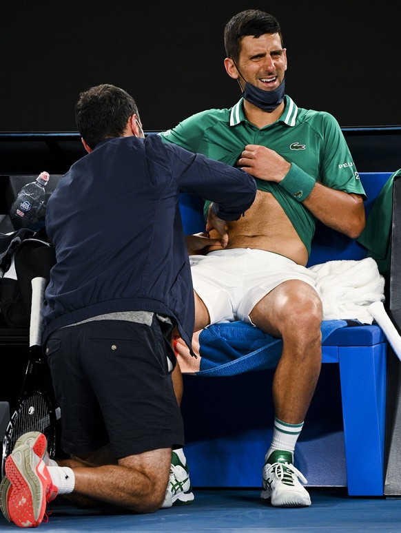 epa09006643 Novak Djokovic of Serbia receives medical attention during his third Round Men&#039;s singles match against Taylor Fritz of the United States of America on Day 5 of the Australian Open at  ...