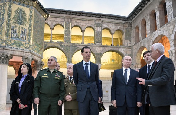 epa08111748 Syrian President Bashar Assad (C), Russian President Vladimir Putin (3-R) and Russian Defence Minister Sergey Shoygu (2-L) during their visit Umayyad Mosque in Damascus, Syria, 07 January  ...