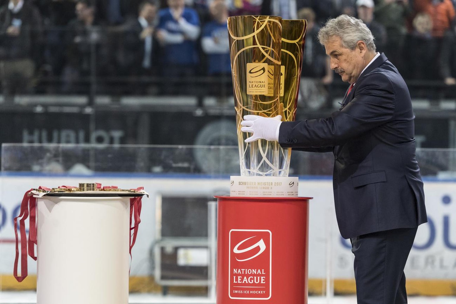 Der Leiter Spielbetrieb der Nationalliga, Willi Voegtlin richtet den Meisterpokal fuer die Siegerehrung nach dem sechsten Eishockey Playoff-Finalspiel der National League A zwischen dem EV Zug und dem ...