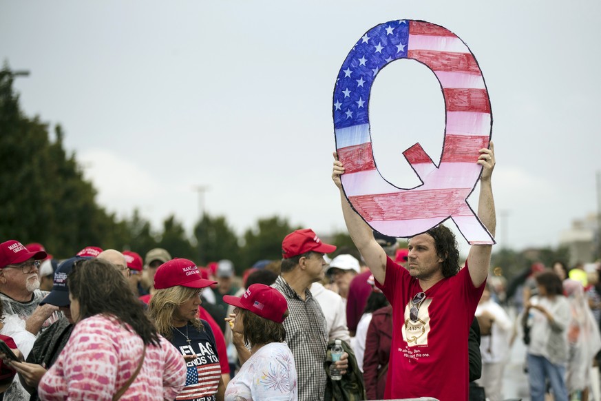 FILE - In this Aug. 2, 2018, file photo, David Reinert holding a Q sign waits in line with others to enter a campaign rally with President Donald Trump in Wilkes-Barre, Pa. A far-right conspiracy theo ...