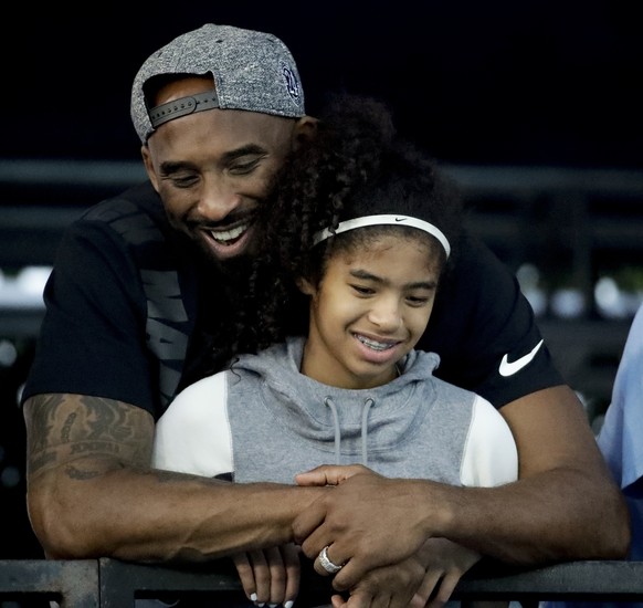 FILE - In this July 26, 2018 file photo former Los Angeles Laker Kobe Bryant and his daughter Gianna watch during the U.S. national championships swimming meet in Irvine, Calif. Bryant, the 18-time NB ...