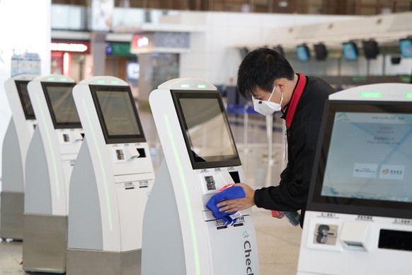 epa08387101 A handout photograph provided by Hong Kong International Airport shows a worker spraying disinfectant on a check in kiosk in Hong Kong International Airport in Hong Kong, China, 24 April 2 ...