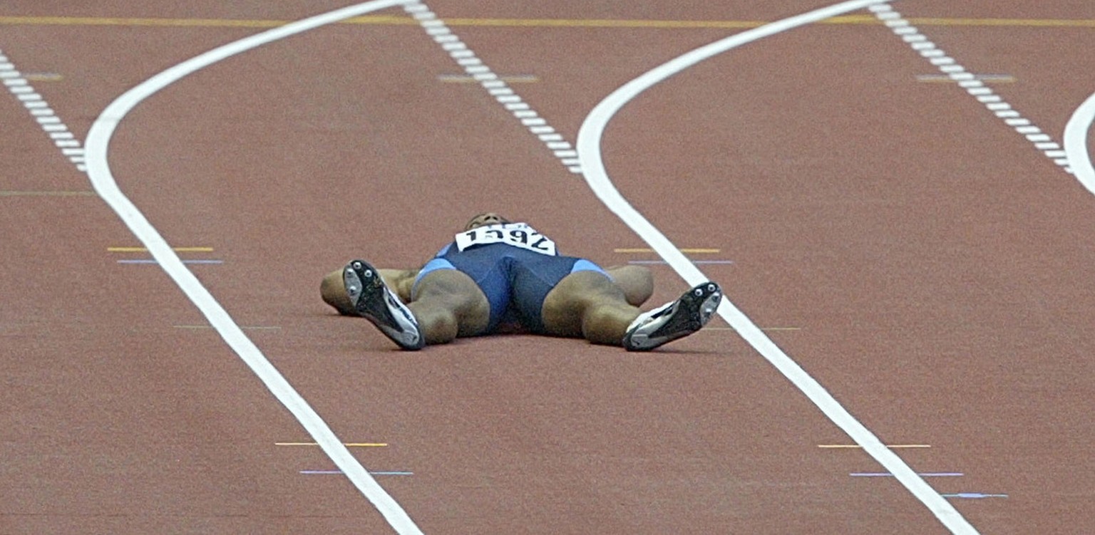 Jon Drummond of the US lies on the track in protest against a false start decision at the start of his Men&#039;s 400 meter quarterfinal at the World Athletics Championships in the Stade de France, Sa ...