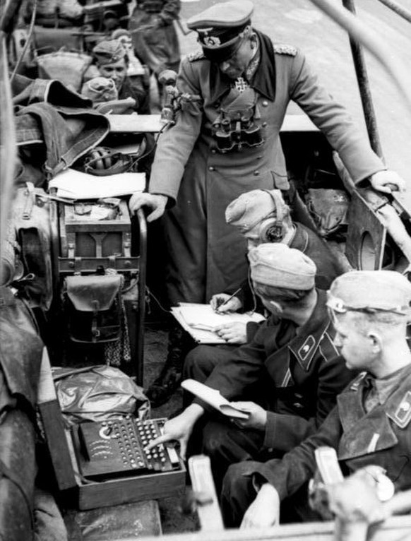 Eine Enigma im Einsatz während des Zweiten Weltkriegs. Unter den Augen von General Heinz Guderian empfängt ein Funker eine Nachricht, die von einem Soldaten an der Eingma entschlüsselt wird. Auf der T ...