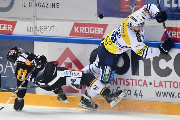 Lugano’s player Steve Hirschi, left, fights for the puck with Ambri&#039;s player Adrien Lauper, right, during the preliminary round game of National League A (NLA) Swiss Championship 2016/17 between  ...
