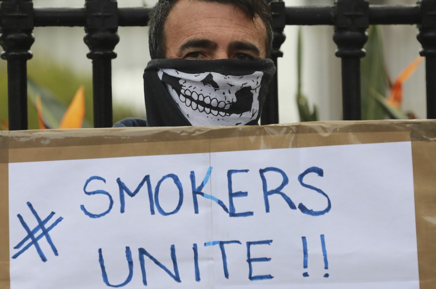 In this June 2, 2020 photo a demonstrator holds a placard during a protest against the tobacco ban outside parliament in Cape Town, South Africa. An effort to lift South Africa���s ban on cigarette sa ...
