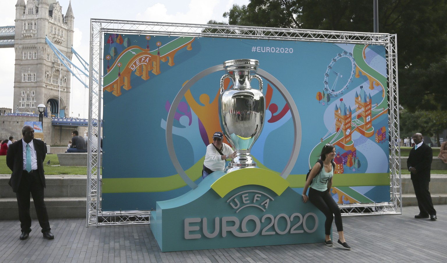 FILE - In this Wednesday Sept. 21, 2016 file photo people pose with a version of the logo on display during the launch event of UEFA Euro 2020 and the unveiling of the tournament brand and the London  ...