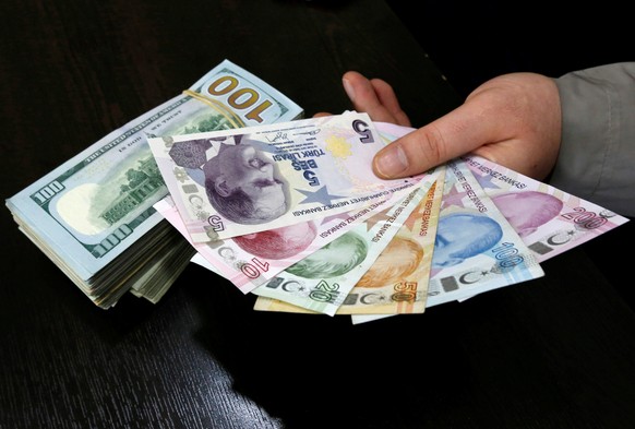 FILE PHOTO - A money changer holds Turkish lira banknotes next to U.S. dollar bills at a currency exchange office in central Istanbul April 15, 2015. REUTERS/Murad Sezer/File Photo