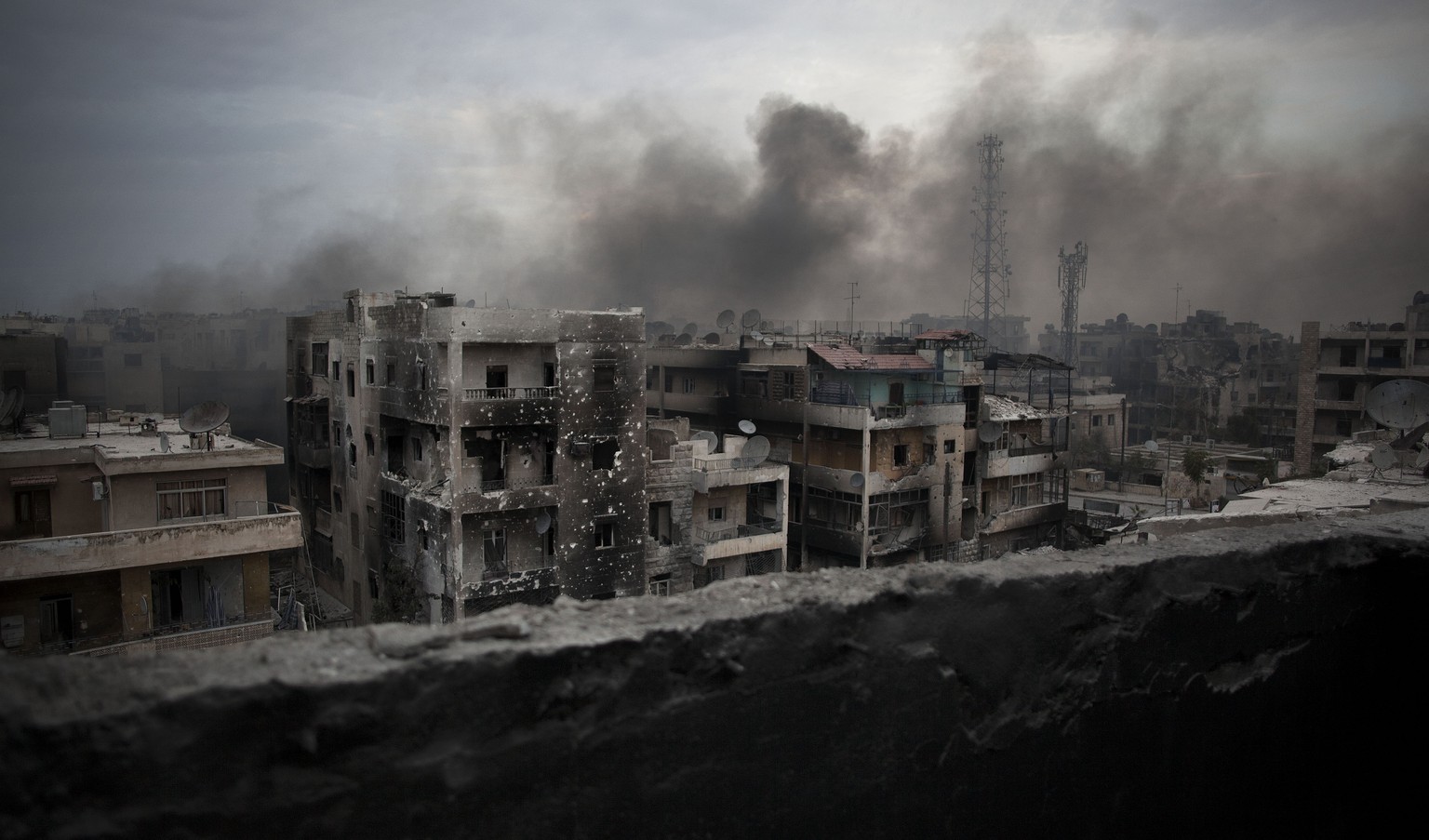 FILE - In this Oct. 2, 2012 file photo, smoke rises over Saif Al Dawla district, in Aleppo, Syria. Syrians are marking 10 years since peaceful protests against President Bashar Assad&#039;s government ...