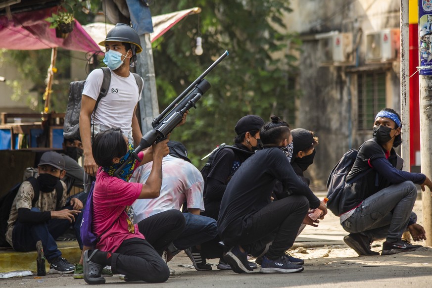 Anti-coup protesters aim to defend themselves with homemade air rifles during a demonstration against the military coup in Yangon, Myanmar, Saturday, April 3, 2021. Threats of lethal violence and arre ...