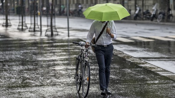 Ein Mann mit einem Schirm laeuft im Regen in Bern, am Mittwoch, 8. August 2018. (KEYSTONE/Thomas Hodel)