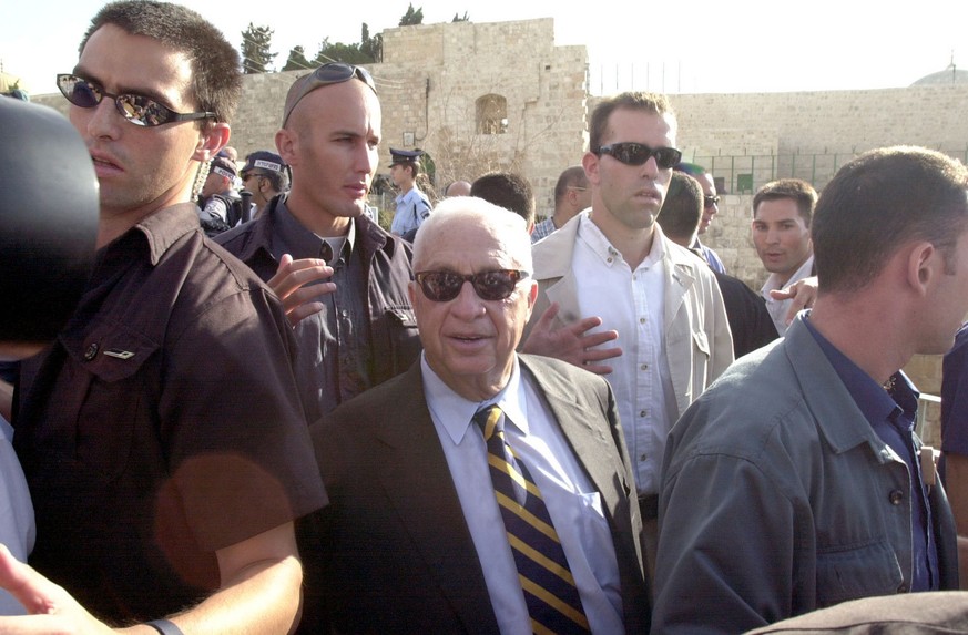 Israeli security men seround opposition leader Ariel Sharon, centre, as he leaves the Tempel Mount compound in east Jerusalem&#039;s Old City Thursday Sept. 28, 2000. Clashes erupted Thursday in east  ...