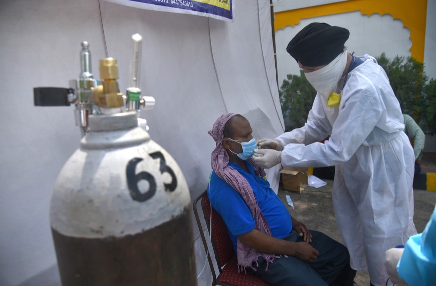 epa09172028 A suspected COVID-19 patient receives oxygen supply at a Sikh shrine, or gurdwara, where oxygen is made available for free by various Sikh religious organizations in New Delhi, India, 01 M ...