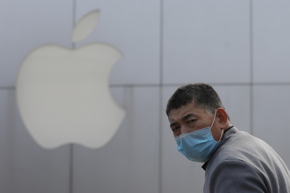 epa08186956 A man wears mask as he walks past a closed Apple store at Sanlitun in Beijing, China, 02 February 2020. Apple announced the closure of its stores, corporate offices and contact centers on  ...