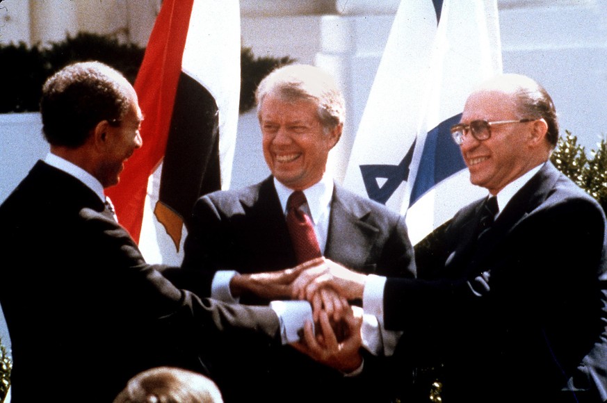 Egyptian President Anwar Sadat, left, U.S. President Jimmy Carter, center, and Israeli Prime Minister Menachem Begin clasp hands on the north lawn of the White House March 26, 1979, as they completed  ...