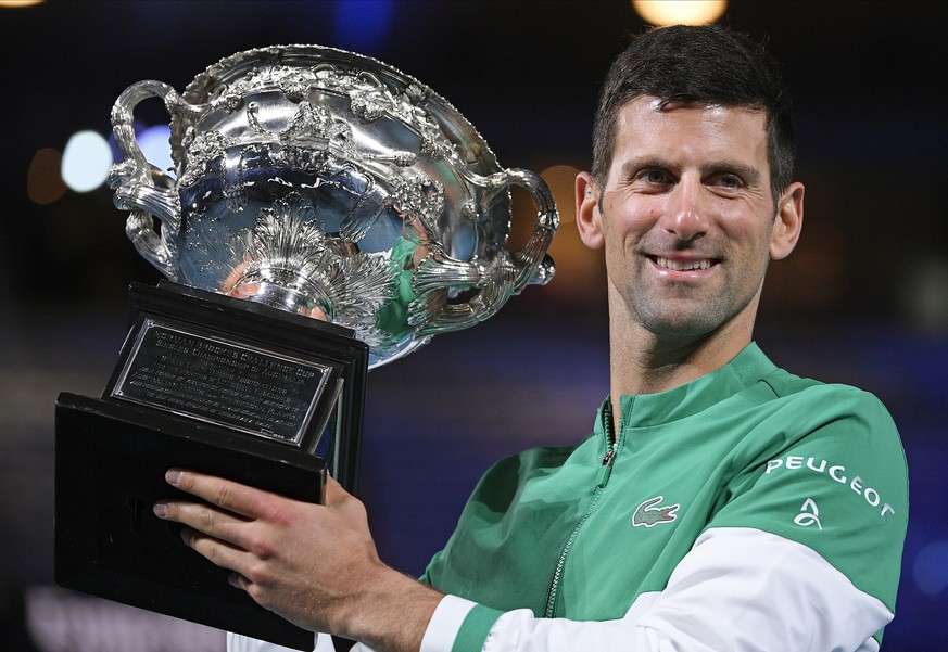 Serbia&#039;s Novak Djokovic holds the Norman Brookes Challenge Cup after defeating Russia&#039;s Daniil Medvedev in the men&#039;s singles final at the Australian Open tennis championship in Melbourn ...