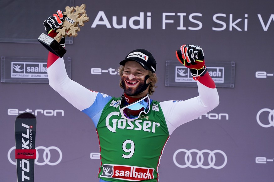 Switzerland&#039;s Marco Odermatt wears a face mask to curb the spread of COVID-19 as he celebrates on the podium after winning an alpine ski, men&#039;s World Cup super G, in Saalbach-Hinterglemm, Au ...