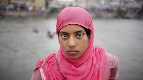 epa07650043 Bangladeshi girl stands on a ferry crossing the Buriganga river view in Dhaka, Bangladesh, 15 June 2019. The Buriganga River is economically very important to Dhaka, used to transport a mu ...