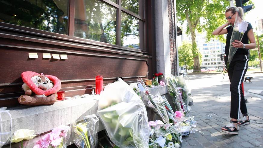 epa06772656 A woman places flowers to pay tribute to the victims of the shooting in front of the Cafe &#039;Les Augustins&#039;, in Liege, Belgium, 30 May 2018. On 29 May, a gunman was shot dead by an ...