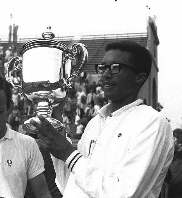 Arthur Ashe, of Richmond, Va., holds his trophy after defeating Tim Okker from the Netherlands, 14-12, 5-7, 6-3, 3-6, 6-3, to claim his first U.S. Open Tennis Championship, in Forest Hills, NY, Sept.  ...