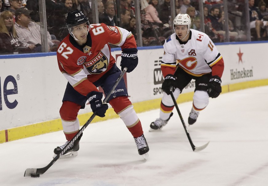 Florida Panthers center Denis Malgin skates with the puck against Calgary Flames center Mikael Backlund during the first period of an NHL hockey game Thursday, Feb. 14, 2019, in Sunrise, Fla. (AP Phot ...