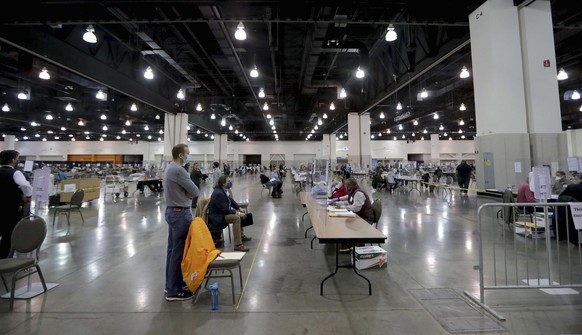 Election workers recount ballots at the presidential election recount at the Wisconsin Center Saturday, Nov. 21, 2020, in Milwaukee. Election officials in Wisconsin���s largest county accused observer ...