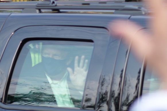 President Donald Trump drives past supporters gathered outside Walter Reed National Military Medical Center in Bethesda, Md., Sunday, Oct. 4, 2020. Trump was admitted to the hospital after contracting ...