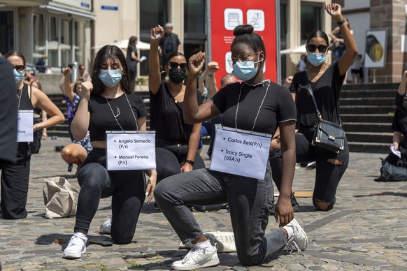 Teilnehmer an einer Platzkundgebung gegen Rassismus, Exit Racism Now!, knien sich mit einer erhobenen Faust auf den Boden auf dem Barfuesserplatz in Basel, am Samstag, 4. Juli 2020. (KEYSTONE/Georgios ...