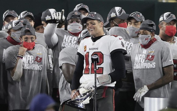 epa08963313 Tampa Bay Buccaneers quarterback Tom Brady holds the George Halas Trophy after defeating the Green Bay Packers in their NFL NFC Championship game at Lambeau Field in Green Bay, Wisconsin,  ...