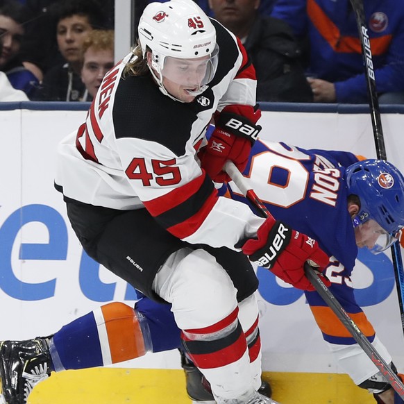 New Jersey Devils defenseman Sami Vatanen (45) controls the puck after checking New York Islanders center Brock Nelson (29) against the boards during the second period of an NHL hockey game, Thursday, ...