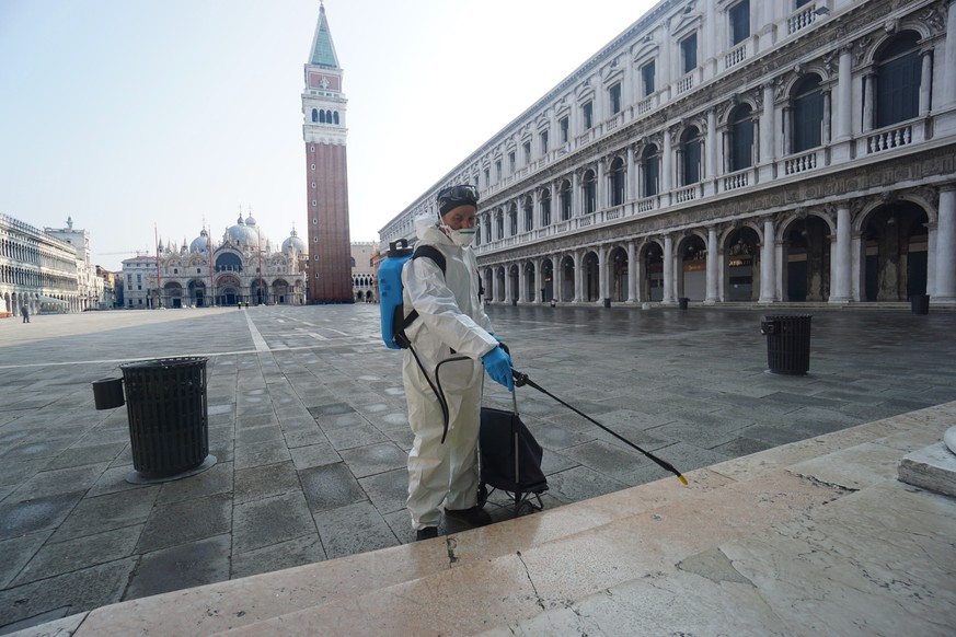 epa08288286 A sanitation employee disinfects the historical Marciana area of Venice, Italy, 12 March 2020. Venice&#039;s waste management provider Veritas is set to close down all waste collection cen ...