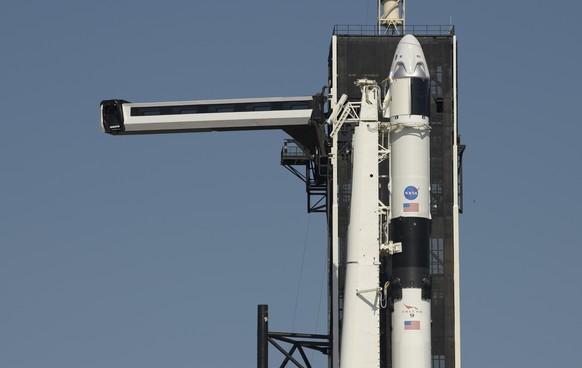 epa08435974 A handout photo made available by NASA shows the crew access arm is swung into position for the Crew Dragon spacecraft and the SpaceX Falcon 9 rocket at Launch Complex 39A as preparations  ...