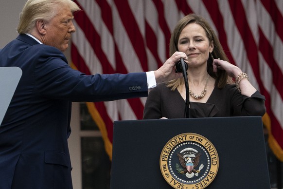 President Donald Trump adjusts the microphone after he announced Judge Amy Coney Barrett as his nominee to the Supreme Court, in the Rose Garden at the White House, Saturday, Sept. 26, 2020, in Washin ...