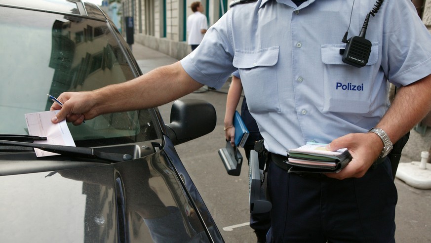 Ein Mitarbeiter des Polizeilichen Assistenzdienstes (PAD) verteilt am 4. August 2004 in Zuerich Strafzettel wegen Falschparkens. Der Polizeiliche Assistenzdienst ist eine Dienstabteilung der Zuercher  ...