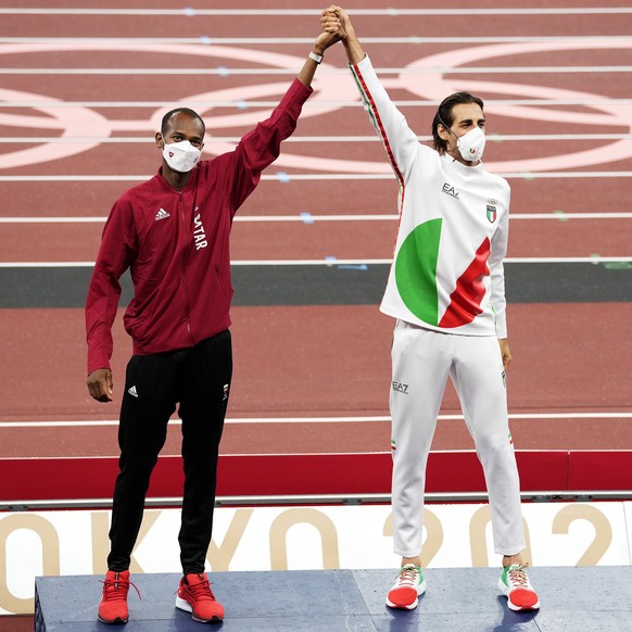 epa09387726 Joint gold medalists Mutaz Essa Barshim (L) of Qatar and Gianmarco Tamberi of Italy during the medal ceremony for the Men&#039;s High Jump at the Athletics events of the Tokyo 2020 Olympic ...