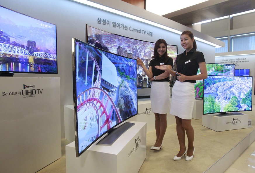 Models pose with a Samsung Electronics curved UHD TV during a press unveiling at its headquarters in Seoul, South Korea, Thursday, Feb. 20, 2014. Samsung Electronics Co. launched the world&#039;s firs ...