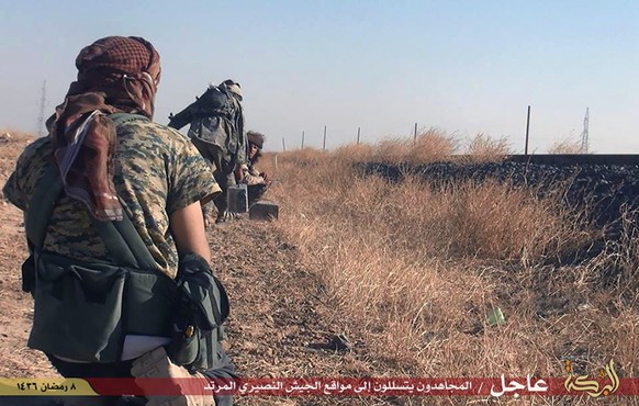 In this photo provided by a website of the Islamic State militants, taken Thursday, June 25, 2015, Islamic State militants move toward Syrian government forces&#039; positions in the predominantly Kur ...