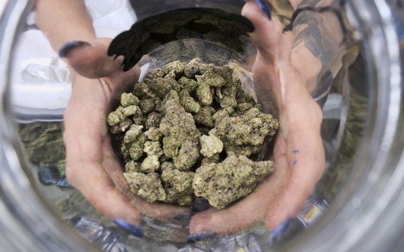 FILE - In this April 21, 2018, file photo a bud tender displays a jar of cannabis at the High Times 420 SoCal Cannabis Cup in San Bernardino, Calif. California faced off in court Thursday, Aug. 6, 202 ...