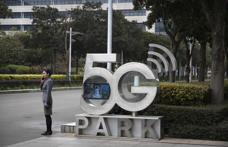 FILE - In this file photo dated Thursday, Dec. 5, 2019, an Huawei employee talks on a cellphone, as she stands next to a sign at Huawei&#039;s campus in Shenzhen in southern China&#039;s Guandong Prov ...