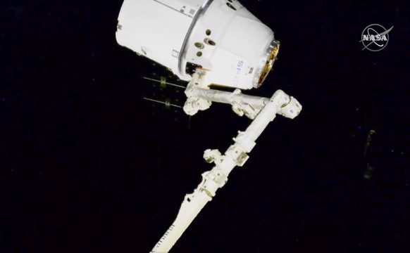 In this image taken from NASA video, NASA astronauts Andrew Morgan and Jessica Meir use the International Space Station&#039;s robot arm to capture the Dragon capsule Monday, March 9, 2020. The Dragon ...