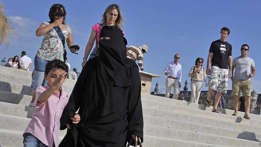 ZUR LEGITIMIERUNG DES BURKA-VERBOTS IN FRANKREICH DURCH DEN EUROAEISCHEN GERICHTSHOF FUER MENSCHENRECHTE STELLEN WIR IHNEN FOLGENDES BILDMATERIAL ZUR VERFUEGUNG - A niqab clad woman walks with a child ...