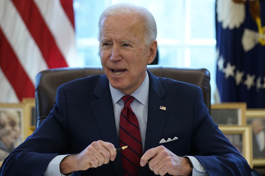 President Joe Biden signs a series of executive orders on health care, in the Oval Office of the White House, Thursday, Jan. 28, 2021, in Washington. The Democratic push to raise the minimum wage to $ ...