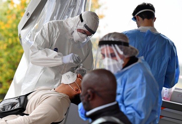 epa08823665 Health workers wearing overalls and protective masks, perform swab tests at the &#039;Santa Maria della Pieta&#039; of the ASL Roma 1 health facilities in Rome, Italy, 16 November 2020. It ...