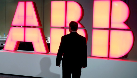 A man stands in front of the logo of Swiss engineering group ABB before a news conference in Zurich, Switzerland October 4, 2016. REUTERS/Arnd Wiegmann/File Photo
