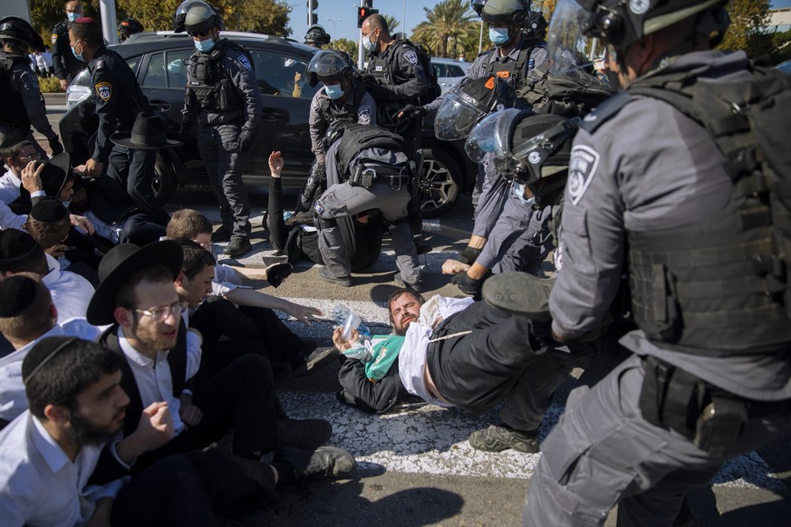 Israeli police officers clash with ultra-Orthodox Jews during a protest over the coronavirus lockdown restrictions, in Ashdod, Israel, Sunday, Jan. 24, 2021. As he seeks re-election, Prime Minister Be ...