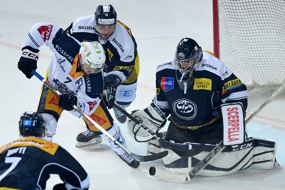 Zug&#039;s player David McIntyre, Ambri&#039;s player Marco Mueller and Ambri&#039;s goalkeeper Benjamin Conz, from left, during a qualification game of the National League between HC Ambrì Piotta and ...