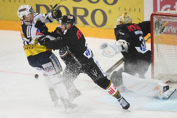 Ambri&#039;s player Johnny Kneubuehler, fights for the puck with Lugano&#039;s player Elia Riva, right, during the regular season game of the National League Swiss Championship 2018/19 derby between H ...