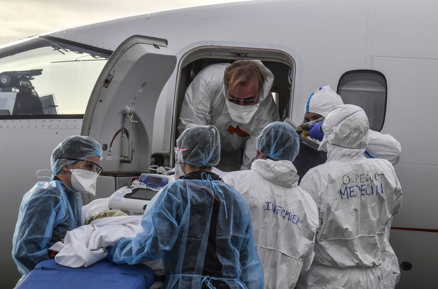Medical staff load a patient affected with COVID-19 aboard a medical plane at Bron airport near Lyon, central France, Monday, Nov. 16, 2020. The number of people hospitalized in France with the virus  ...