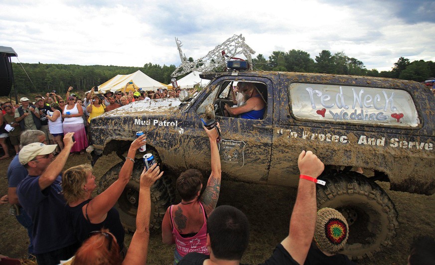 Attendees of the Redneck Olympics in Hebron cheer as a monster truck carrying Lucretia Blais to her wedding with Jeff Gould arrives at the main stage in Hebron, Maine Saturday, August 3, 2013. (Photo  ...